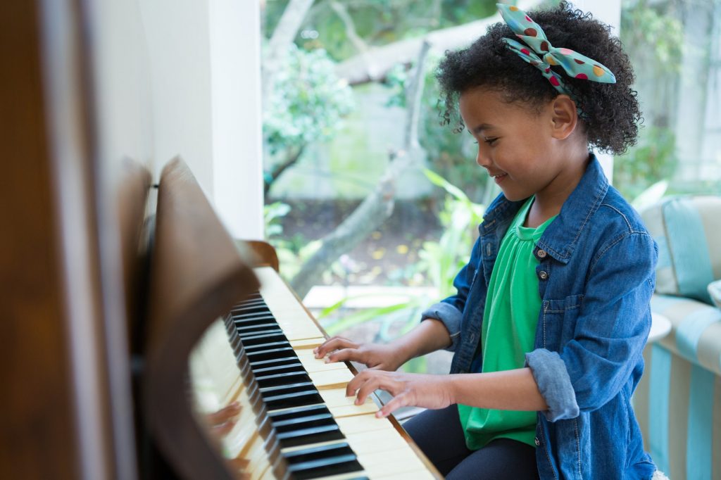 Adorable girl playing piano