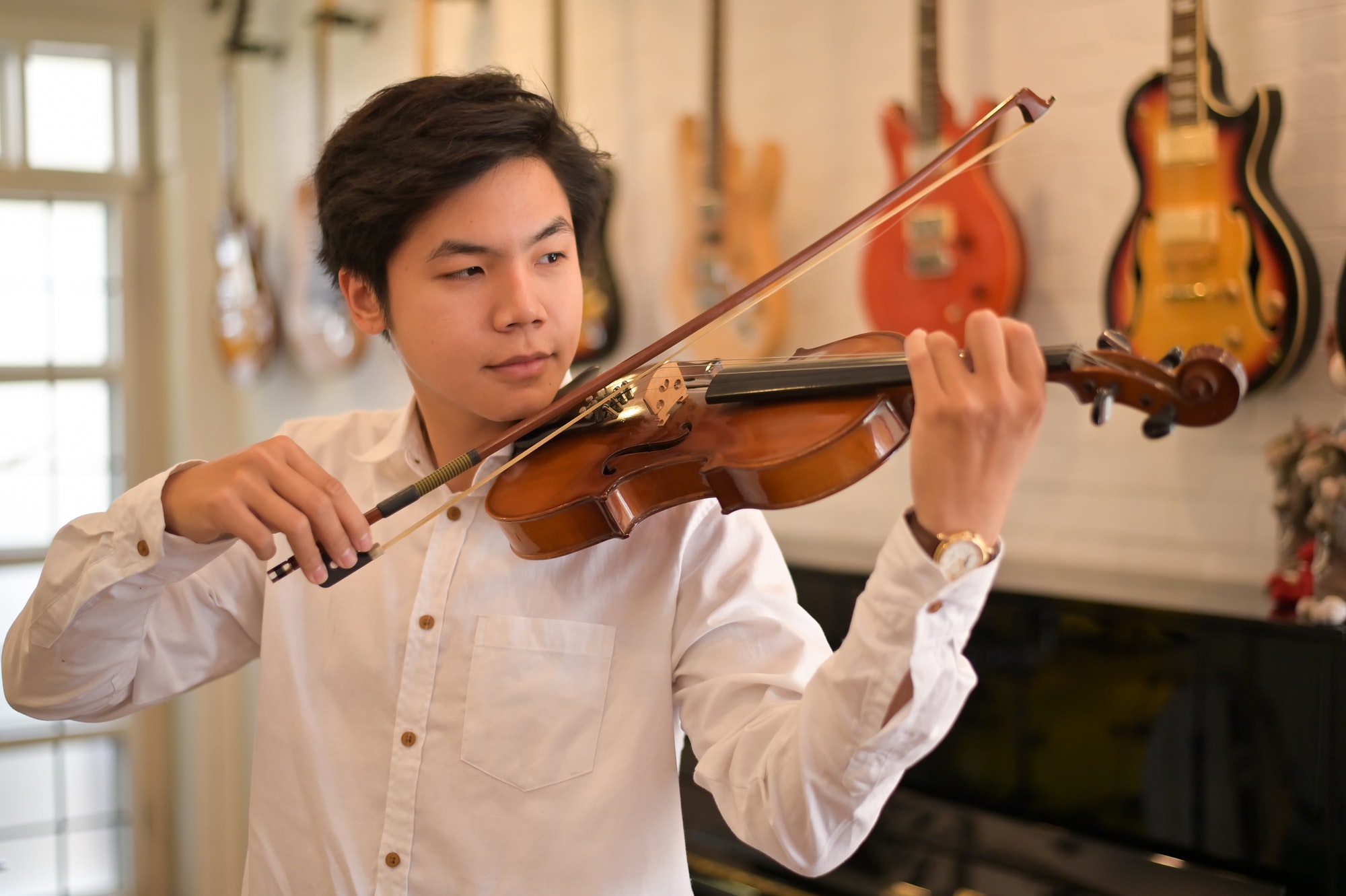 Asian Violinist playing the violin at the home. Musician playing at home.